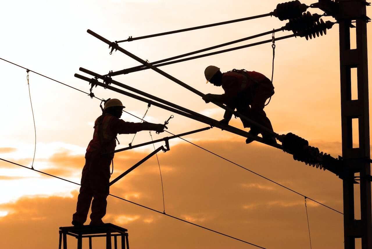 Silhouette of Two Electricians Working on Preventive maintenance