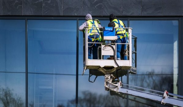 Two man cleaning window on a building
