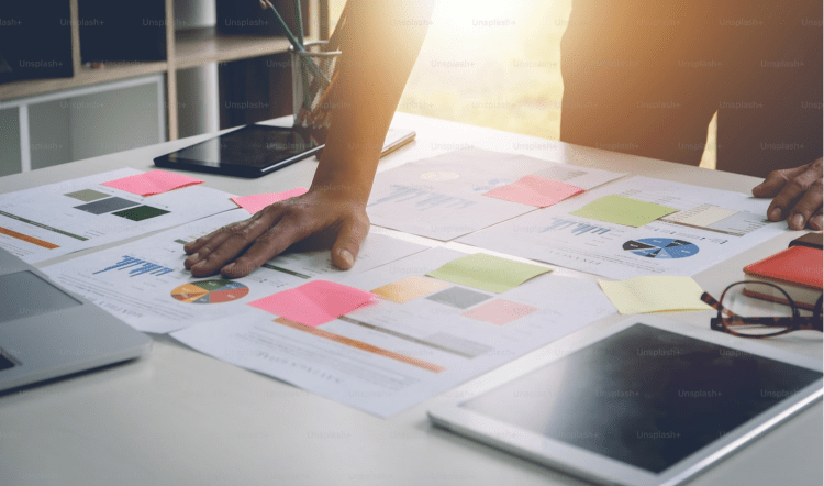 Desk covered in papers with graphs and chart